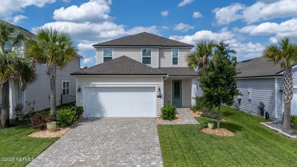 a front view of a house with a garden and trees