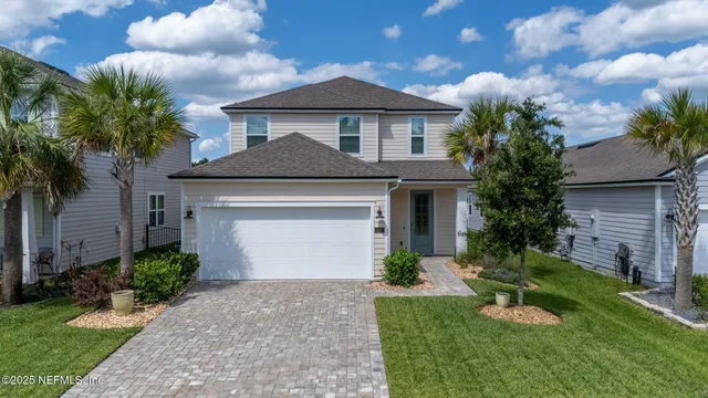 a front view of a house with a garden and trees