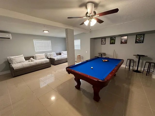 a room with pool table and windows