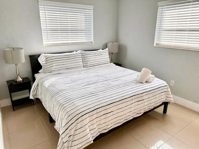 a bedroom with a white bed and a window