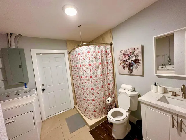 a bathroom with a sink a toilet and shower