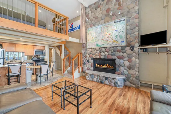 a living room with furniture a flat screen tv and a fireplace