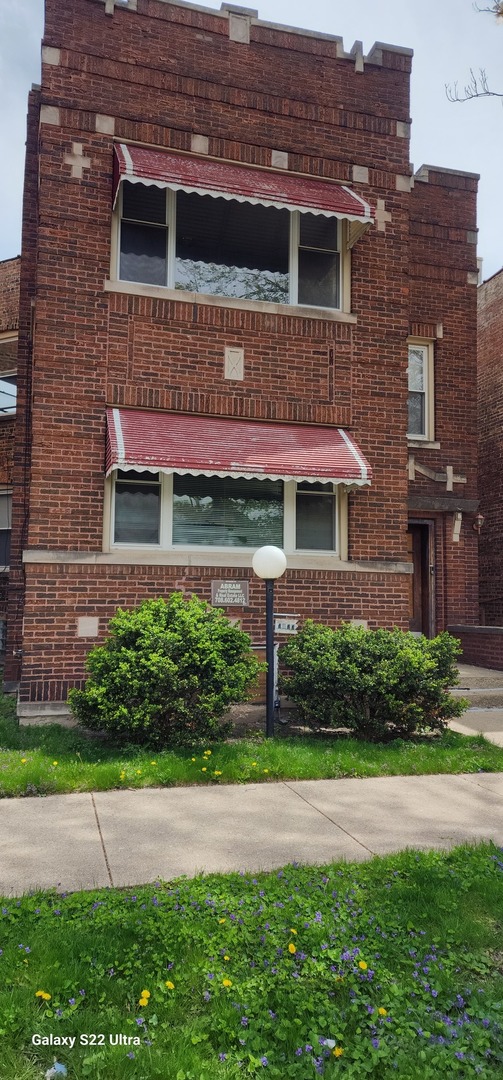 7823 South Evans Avenue, Unit 2 Chicago, IL 60619 - Photo 1 of 13 a front view of a house with a garden