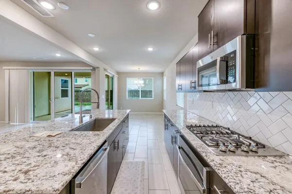 a kitchen with stainless steel appliances granite countertop a stove and a sink