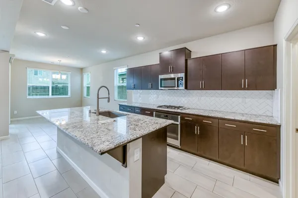 a kitchen with kitchen island granite countertop a sink and counter space