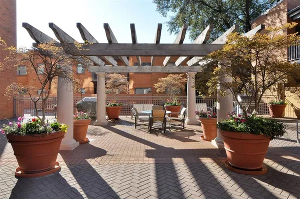 a view of a patio with table and chairs potted plants and a large tree