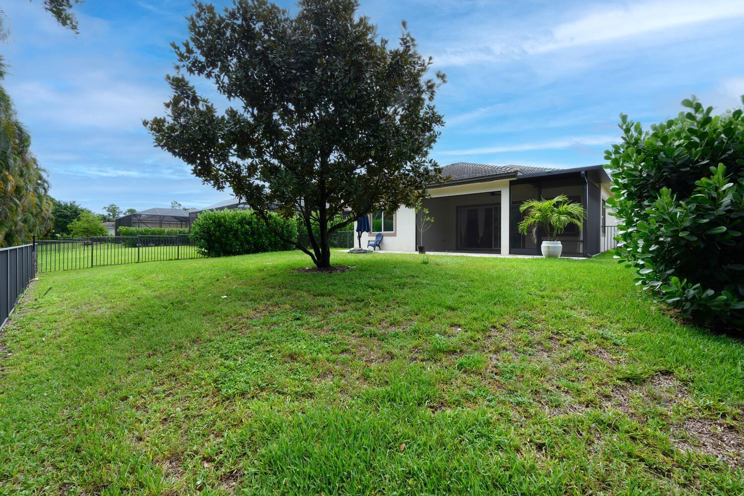 8024 Southwest Marin Drive Stuart, FL 34997 - Photo 20 of 26 a view of a house with a big yard and large trees