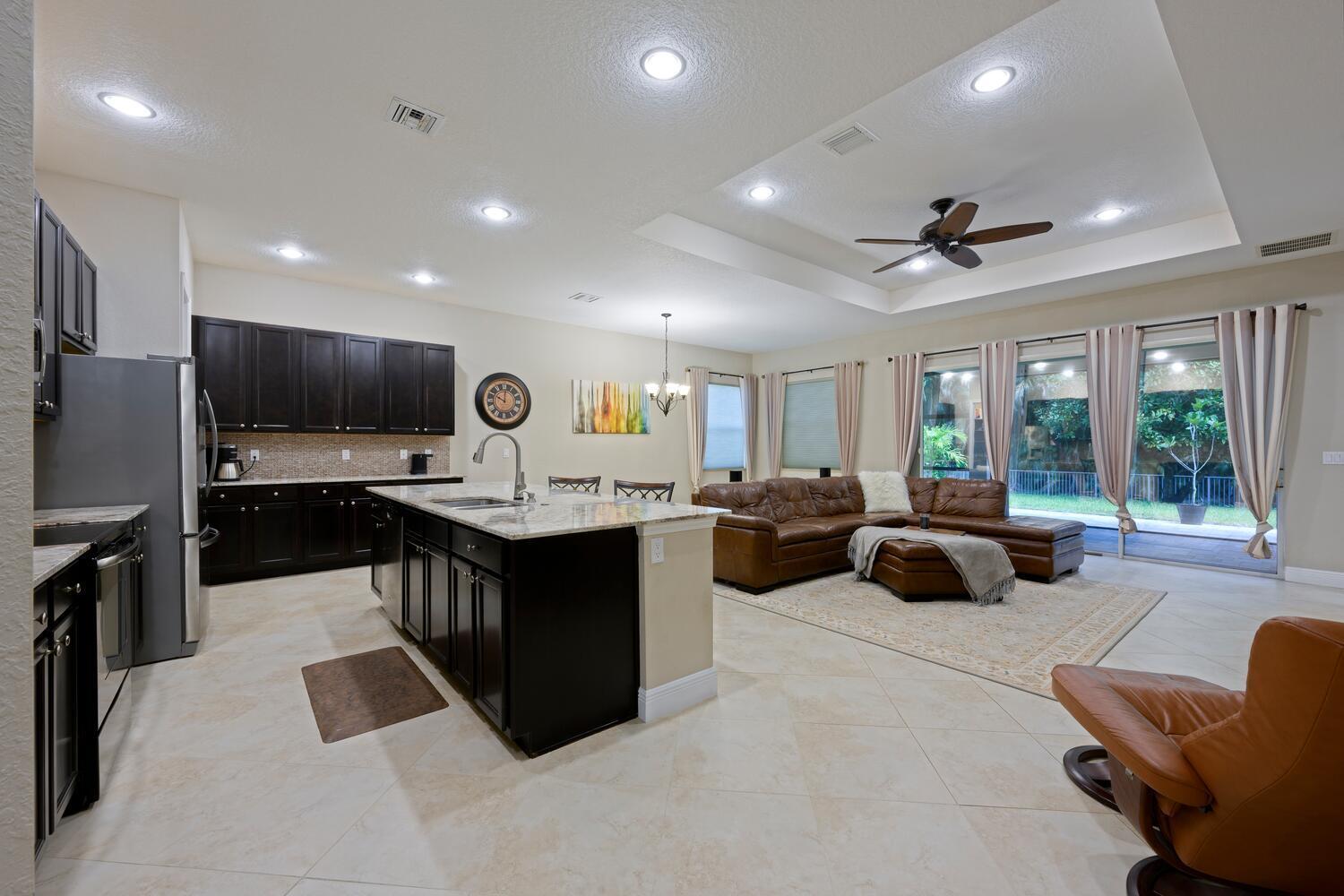 8024 Southwest Marin Drive Stuart, FL 34997 - Photo 5 of 26 a large living room with stainless steel appliances kitchen island granite countertop a couch and a view of living room