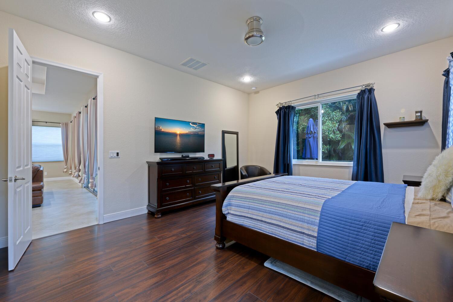 8024 Southwest Marin Drive Stuart, FL 34997 - Photo 9 of 26 a bedroom with a bed and a flat screen tv