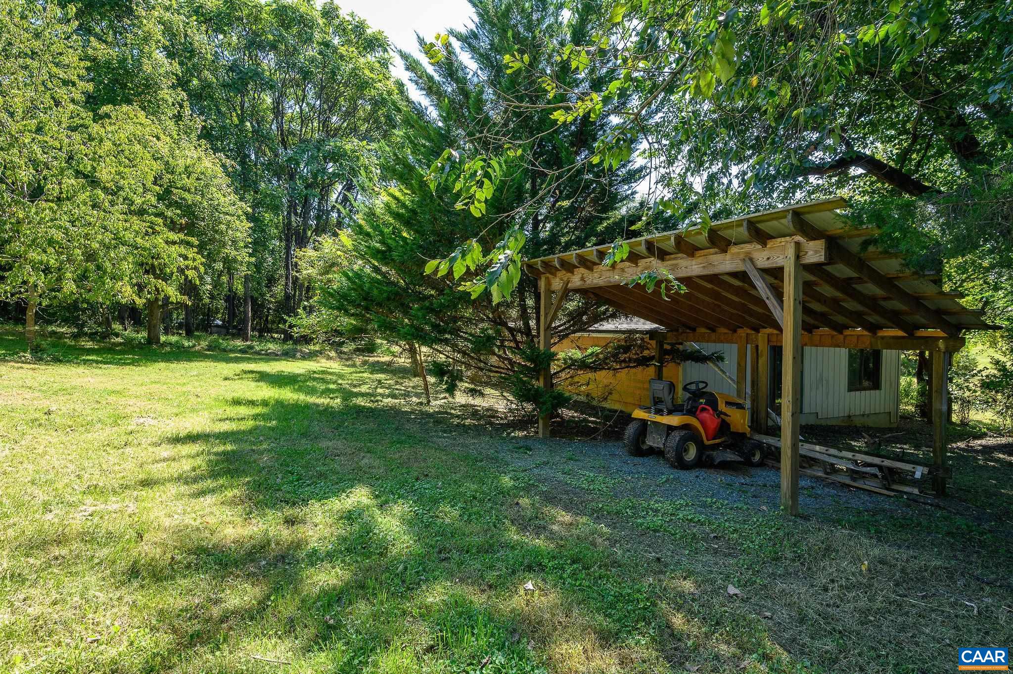 6265 Midway Road Charlottesville, VA 22903 - Photo 39 of 68 a view of a backyard with table and chairs under an umbrella