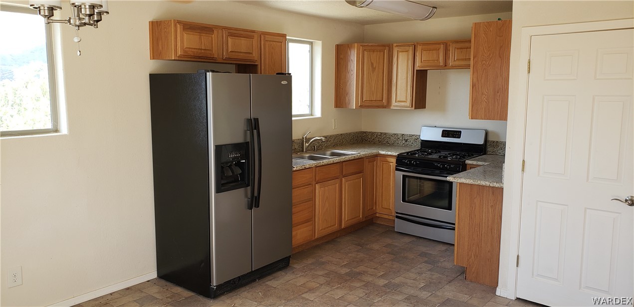 10002 East Blake Ranch Road, Unit 3 Kingman, AZ 86401 - Photo 30 of 42 a kitchen with a refrigerator stove and cabinets
