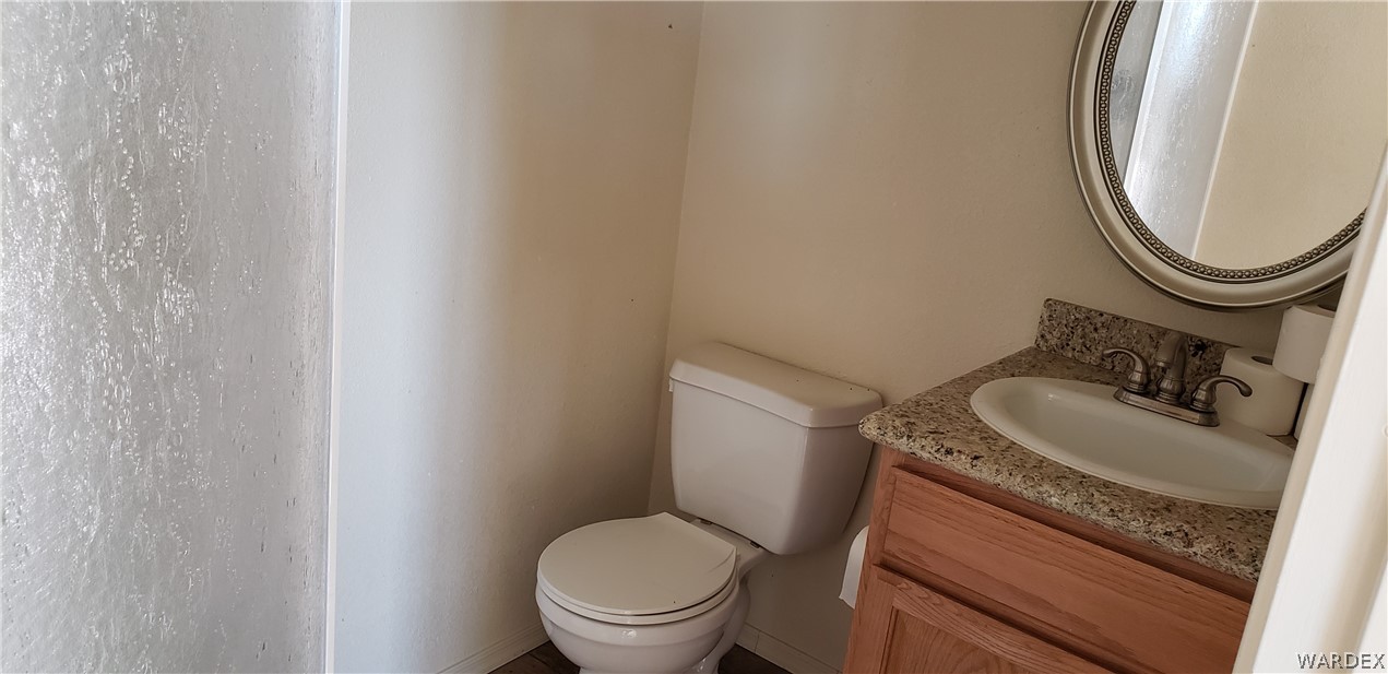 10002 East Blake Ranch Road, Unit 3 Kingman, AZ 86401 - Photo 33 of 42 a bathroom with a granite countertop toilet sink and mirror