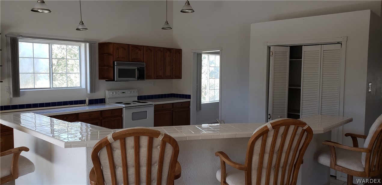10002 East Blake Ranch Road, Unit 3 Kingman, AZ 86401 - Photo 6 of 42 a kitchen with stainless steel appliances granite countertop a sink a microwave cabinets and a dining table