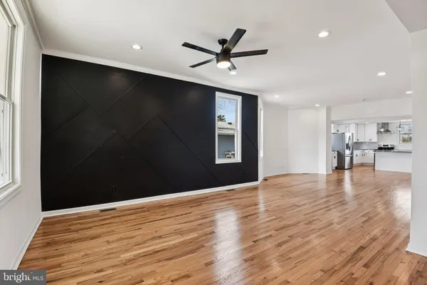 a view of a livingroom with a ceiling fan and wooden floor