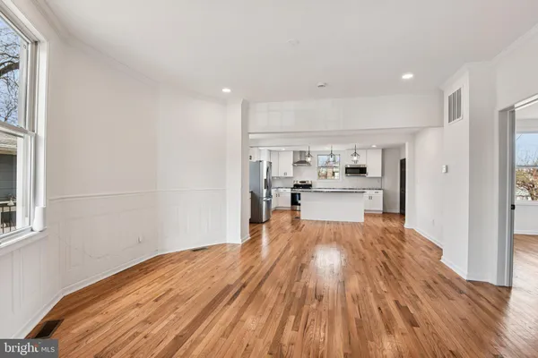 a kitchen with stainless steel appliances granite countertop a refrigerator a stove top oven a sink and dishwasher with wooden floor