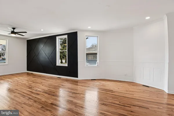 a kitchen with stainless steel appliances granite countertop a stove a sink dishwasher a refrigerator white cabinets and wooden floor