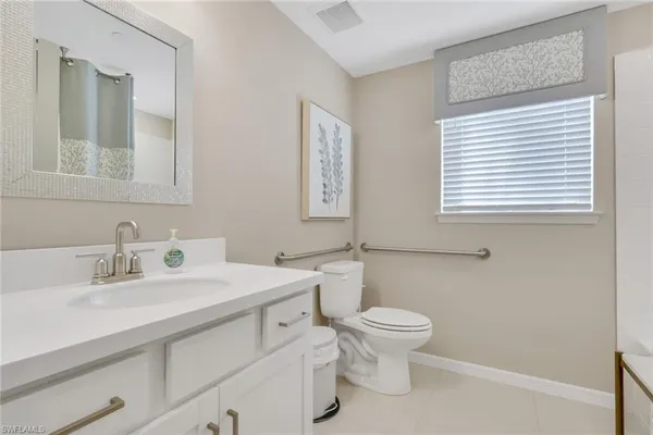 a bathroom with a sink a toilet and a mirror