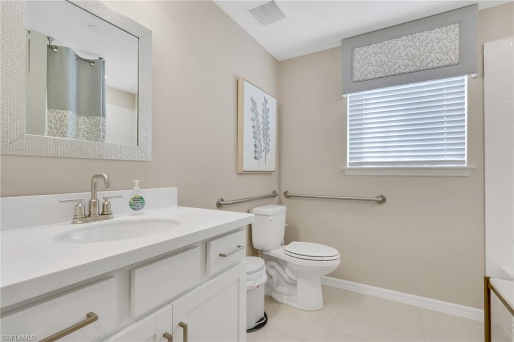 23955 Collina Way, Unit 104 Punta Gorda, FL 33980 - Photo 16 of 45 a bathroom with a sink a toilet and a mirror