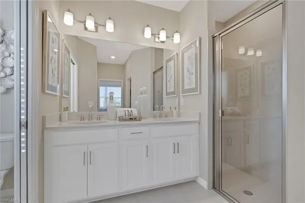 a bathroom with a granite countertop sink a mirror and shower