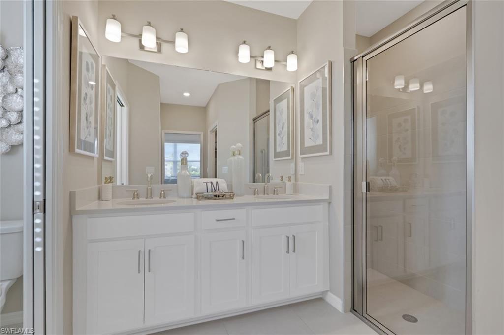 23955 Collina Way, Unit 104 Punta Gorda, FL 33980 - Photo 20 of 45 a bathroom with a granite countertop sink a mirror and shower