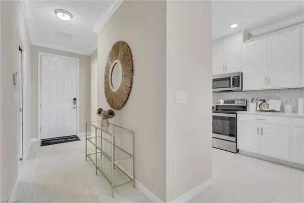 a kitchen with white cabinets and black appliances