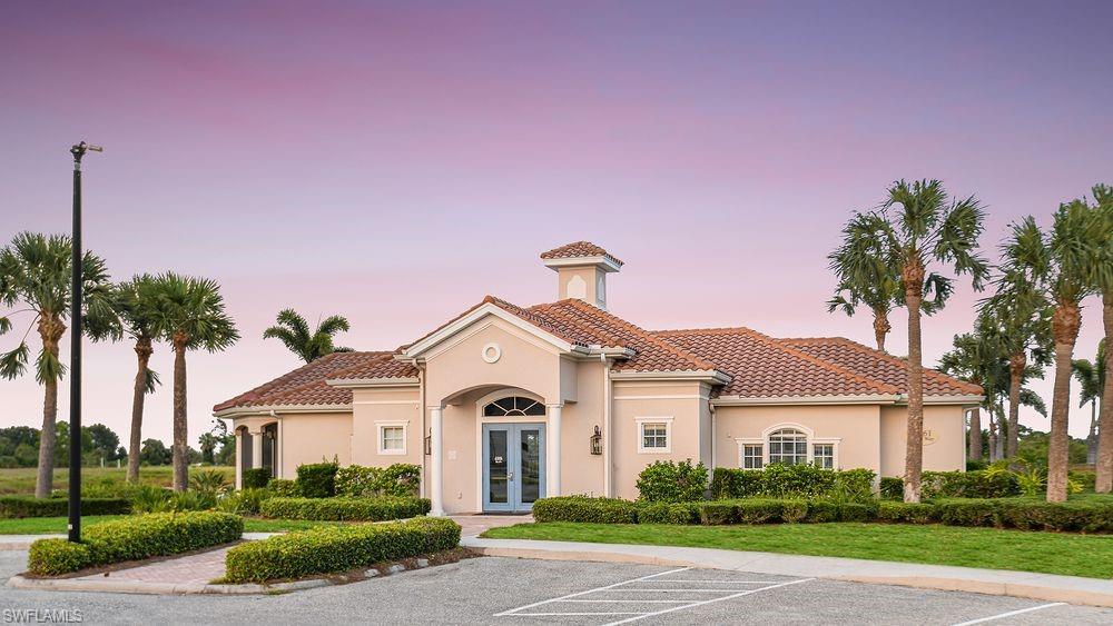 23955 Collina Way, Unit 104 Punta Gorda, FL 33980 - Photo 40 of 45 a front view of a house with a garden and palm trees