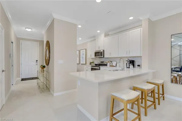 a kitchen with stainless steel appliances a sink a stove a refrigerator and cabinets