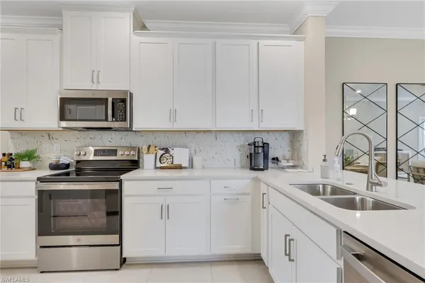 a kitchen with granite countertop white cabinets and stainless steel appliances