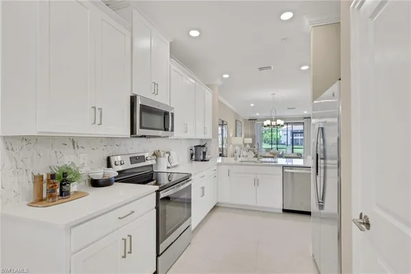 a kitchen with white cabinets and appliances