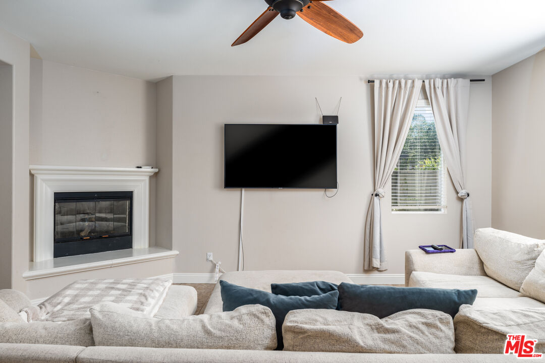14775 Prairie Smoke Road Eastvale, CA 92880 - Photo 12 of 36 a living room with furniture a flat screen tv and a fireplace