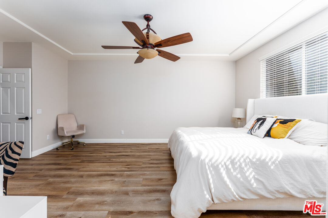 14775 Prairie Smoke Road Eastvale, CA 92880 - Photo 16 of 36 a bedroom with a bed and wooden floor