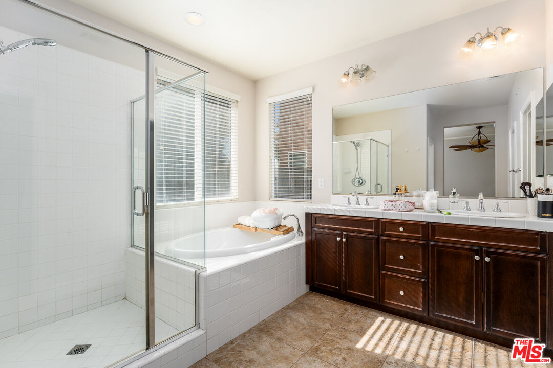 14775 Prairie Smoke Road Eastvale, CA 92880 - Photo 17 of 36 a spacious bathroom with a tub sink shower and mirror