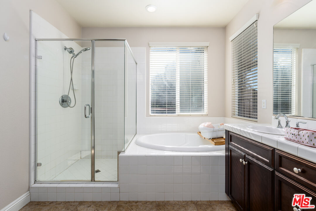 14775 Prairie Smoke Road Eastvale, CA 92880 - Photo 18 of 36 a bathroom with a tub a sink and a window