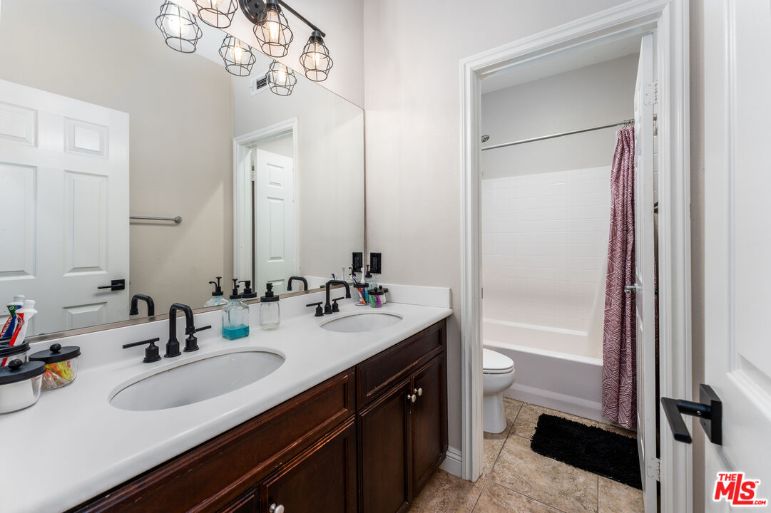 14775 Prairie Smoke Road Eastvale, CA 92880 - Photo 26 of 36 a bathroom with a sink double vanity and a mirror