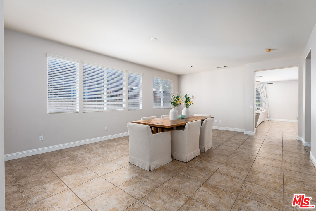 14775 Prairie Smoke Road Eastvale, CA 92880 - Photo 4 of 36 a dining room with kitchen island stainless steel appliances a sink and cabinets