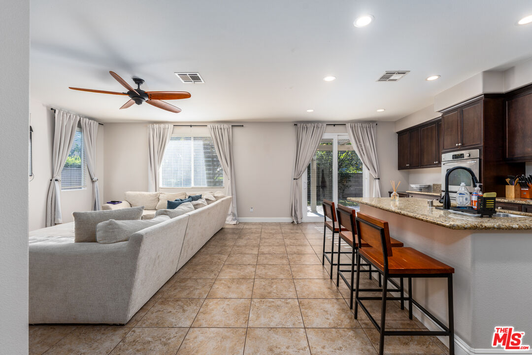 14775 Prairie Smoke Road Eastvale, CA 92880 - Photo 6 of 36 a large white kitchen with a large window and stainless steel appliances