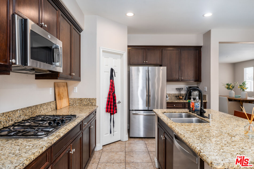 14775 Prairie Smoke Road Eastvale, CA 92880 - Photo 9 of 36 a kitchen with a stove microwave and refrigerator