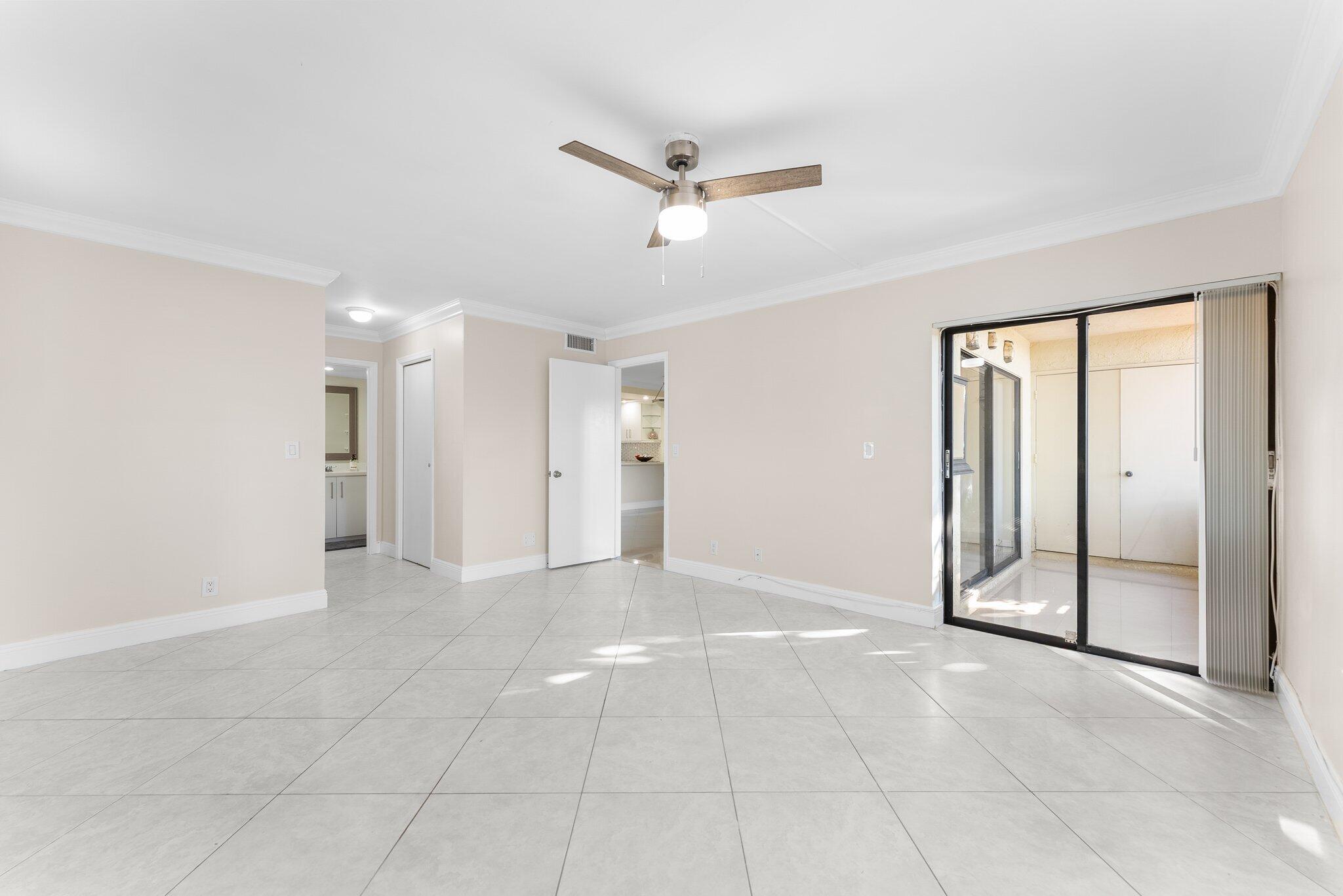 23490 Lyons Road, Unit 605 Boca Raton, FL 33428 - Photo 13 of 39 a view of a livingroom with a ceiling fan & entryway