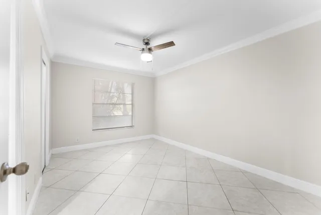an empty room with windows and fan