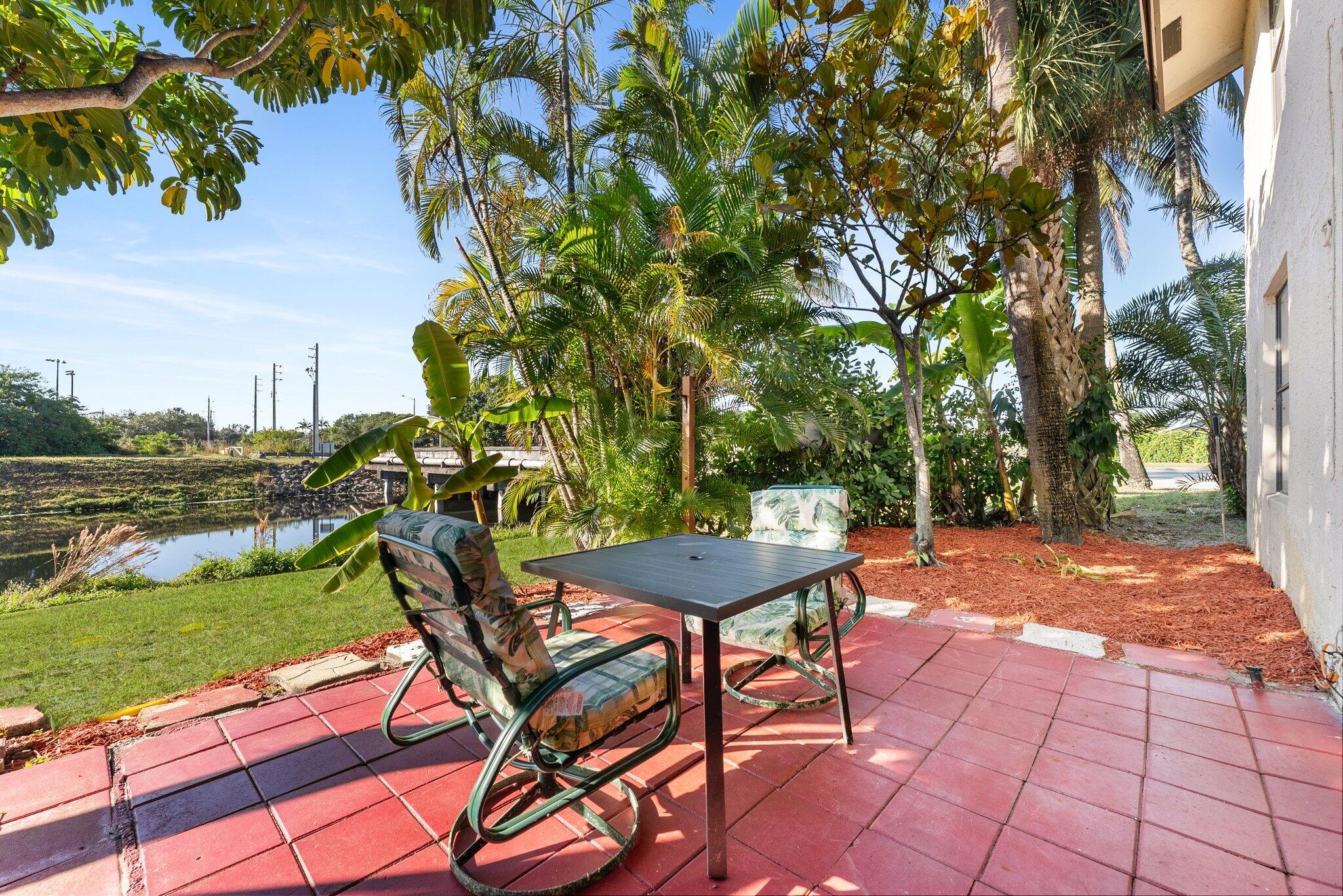 23490 Lyons Road, Unit 605 Boca Raton, FL 33428 - Photo 24 of 39 a backyard of a house with table and chairs