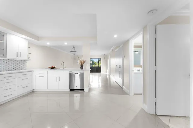 a view of a kitchen with white cabinets and stainless steel appliances