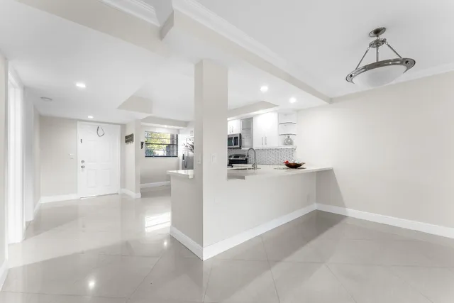 a view of a kitchen with refrigerator and windows