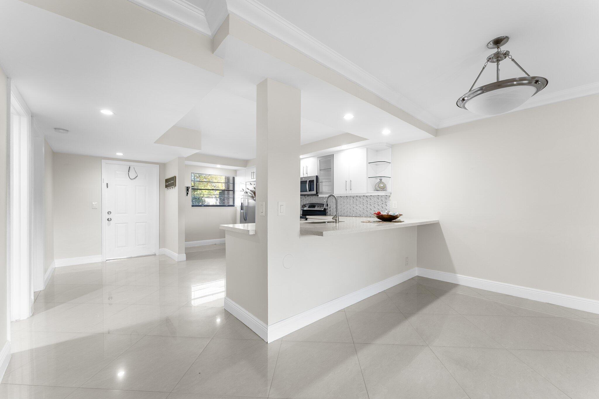 23490 Lyons Road, Unit 605 Boca Raton, FL 33428 - Photo 8 of 39 a view of a kitchen with refrigerator and windows