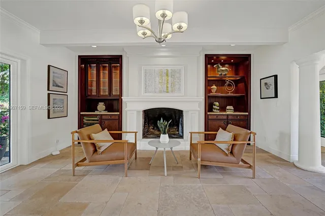 a living room with fireplace furniture and a large window