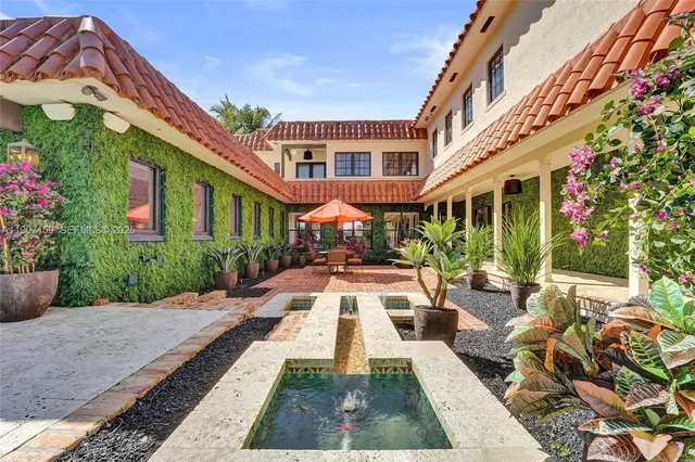 a view of a patio with a table and chairs and potted plants