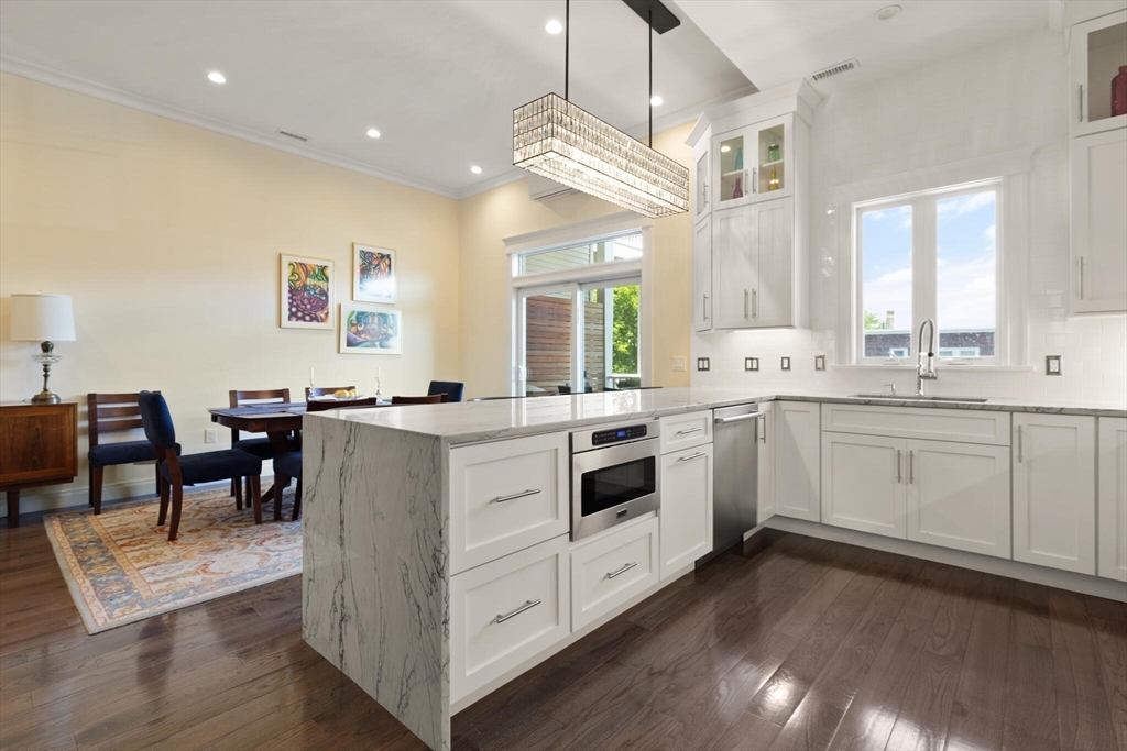 125 Heath Street Somerville, MA 02145 - Photo 14 of 42 a kitchen that has a lot of cabinets in it and wooden floor