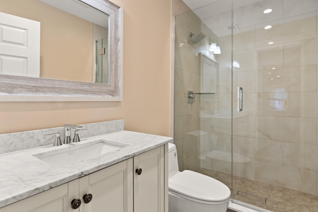 125 Heath Street Somerville, MA 02145 - Photo 32 of 42 a bathroom with a granite countertop sink a toilet and shower