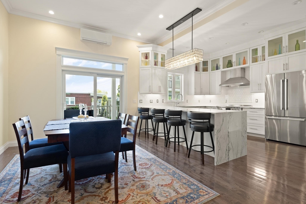 125 Heath Street Somerville, MA 02145 - Photo 9 of 42 a dining room with stainless steel appliances granite countertop a dining table chairs and a refrigerator