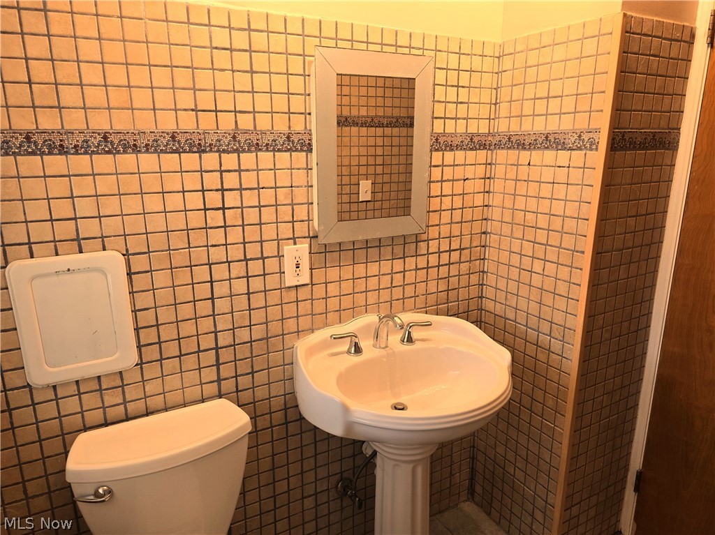 4111 Redfern Road Parma, OH 44134 - Photo 15 of 40 First floor bathroom with pedestal sink, mirrored wall cabinet and toilet