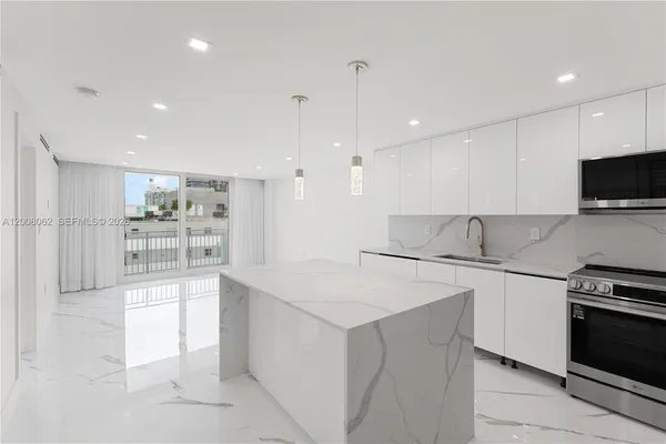 a kitchen with kitchen island a counter top space appliances and cabinets